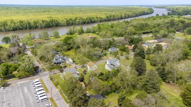 an aerial view of residential houses with outdoor space and trees