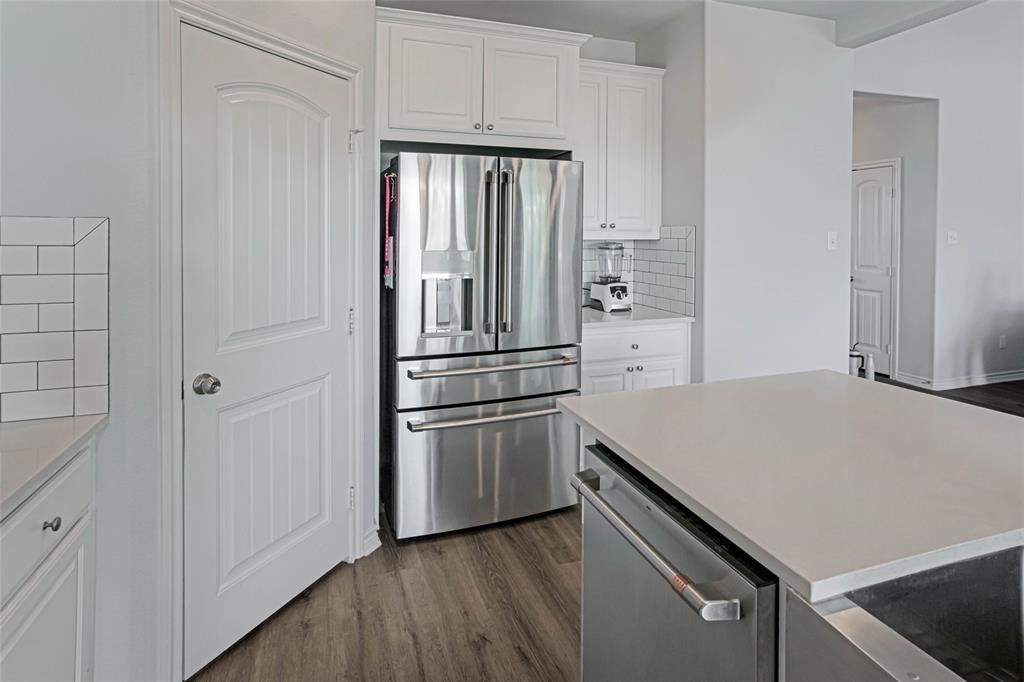 475 Massey Road Gunter, TX 75058 - Photo 17 of 34 Stainless steel refrigerator, white shaker cabinetry, subway tile backsplash, light-toned countertop, and wood-finish flooring
