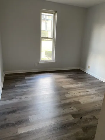 a view of a room with wooden floor and window