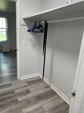 a view of walk in closet with wooden floor