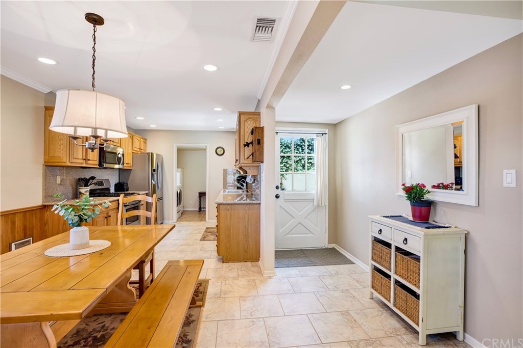 844 Eastman Place San Pedro, CA 90731 - Photo 10 of 44 a view of a kitchen with kitchen island stainless steel appliances wooden floor dining table and a chandelier