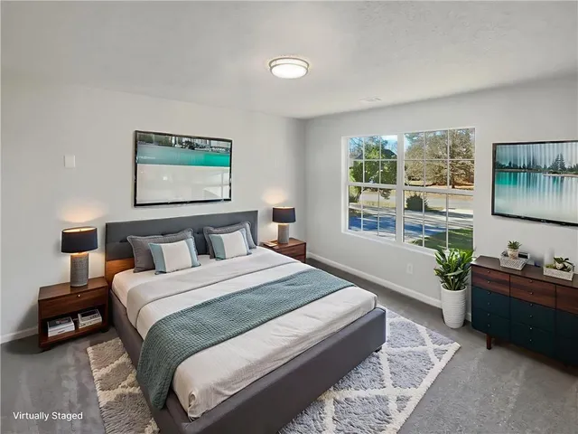 a bedroom with a bed and a large window