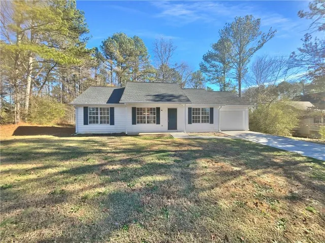 a front view of a house with a large trees