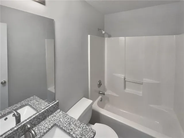 a bathroom with a tub shower sink and vanity
