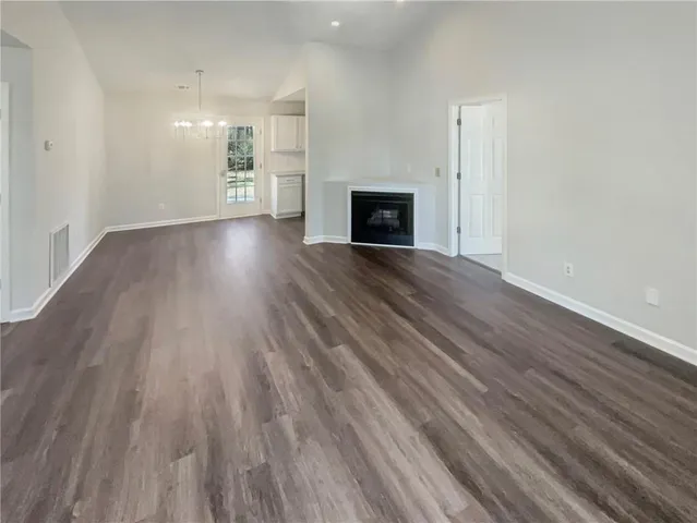 a view of empty room with wooden floor and fireplace