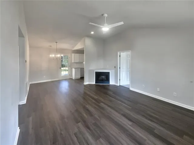 a view of a big room with wooden floor and a kitchen