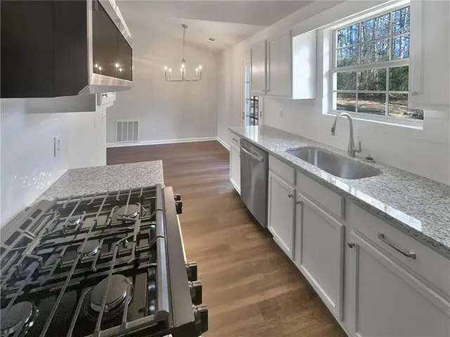a kitchen with granite countertop a sink and a stove