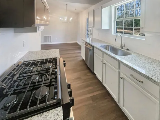 a kitchen with stainless steel appliances granite countertop a stove and a sink