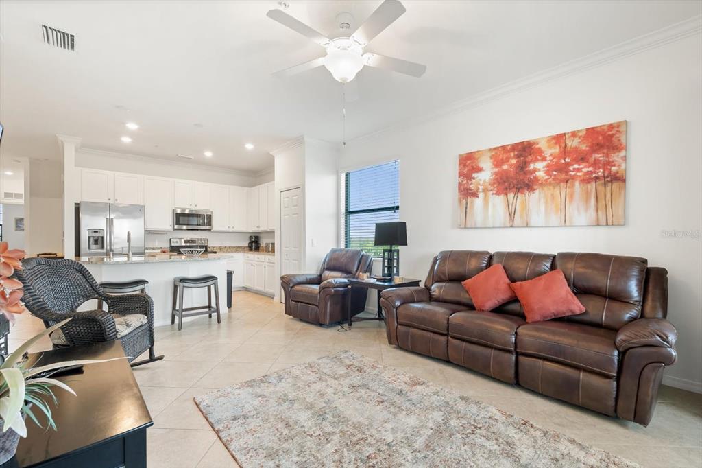 16904 Vardon Terrace, Unit 301 Lakewood Ranch, FL 34211 - Photo 12 of 53 a living room with furniture kitchen view and a dining table