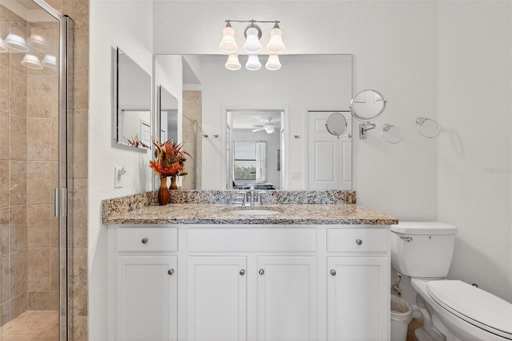 16904 Vardon Terrace, Unit 301 Lakewood Ranch, FL 34211 - Photo 22 of 53 a bathroom with a granite countertop sink a toilet and a mirror