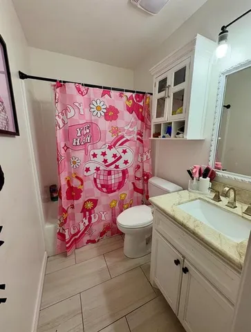 a bathroom with a sink and mirror with toilet