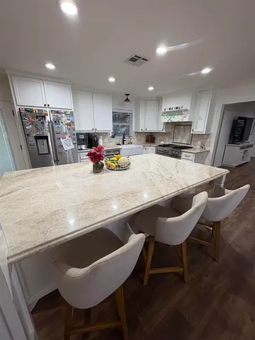 a kitchen with a dining table chairs and refrigerator