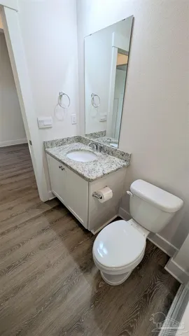 a bathroom with a granite countertop toilet and a sink