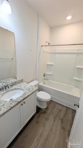 a bathroom with a granite countertop sink a toilet and bathtub