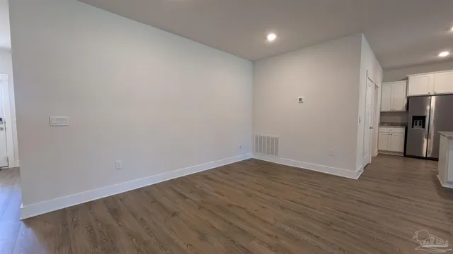 a view of empty room with wooden floor