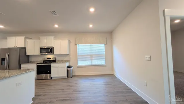 a kitchen with stainless steel appliances granite countertop a stove and a refrigerator