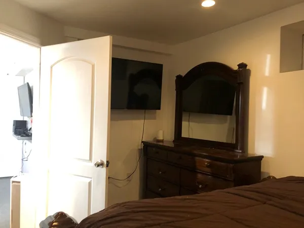 a living room with a bed furniture and a flat screen tv