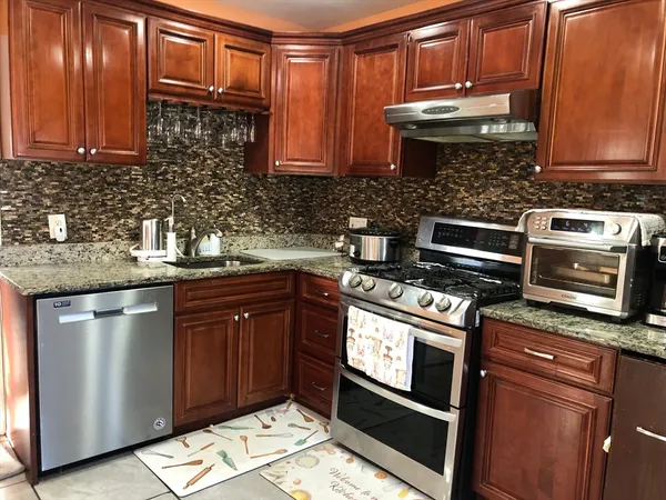 a kitchen with stainless steel appliances granite countertop a stove a microwave and oven