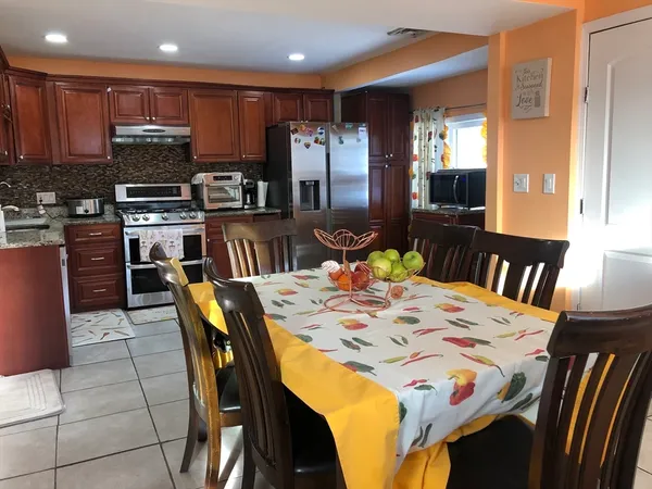 a dining room with a table chairs and a kitchen view