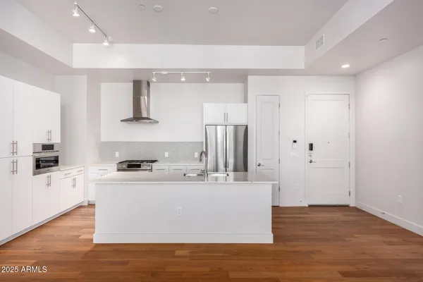 a view of kitchen with granite countertop window and wooden floor