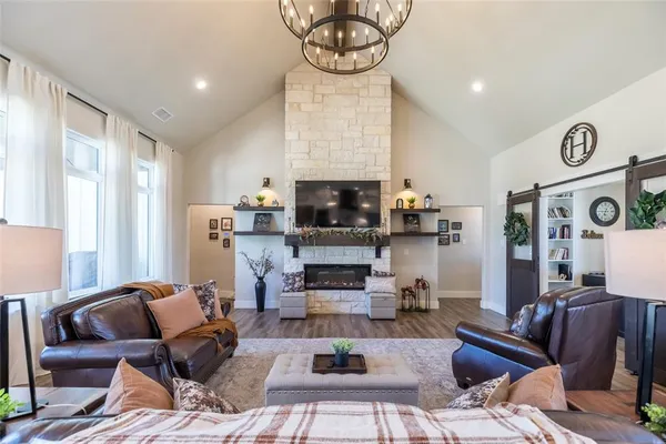 a living room with furniture a flat screen tv and a fireplace