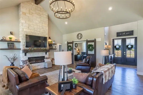 a living room with furniture a fireplace and a chandelier