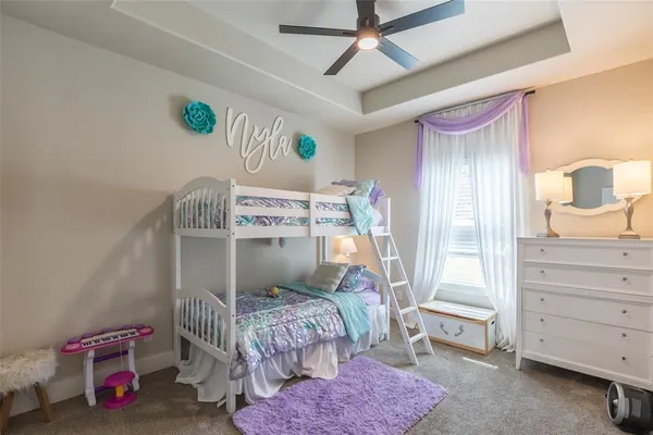a bedroom with a bed a dresser and painting on the wall