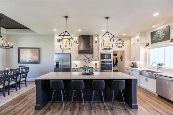 a kitchen with stainless steel appliances granite countertop a kitchen island a stove a table and chairs