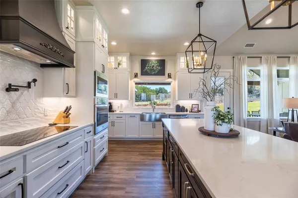a kitchen with stainless steel appliances a sink a stove and a wooden floors
