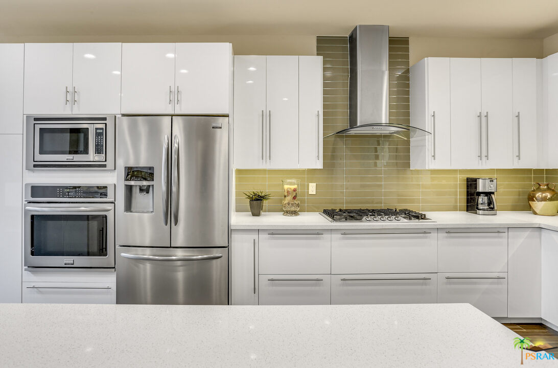 1314 East Andreas Road Palm Springs, CA 92262 - Photo 12 of 34 a kitchen with a refrigerator stainless steel appliances and cabinets
