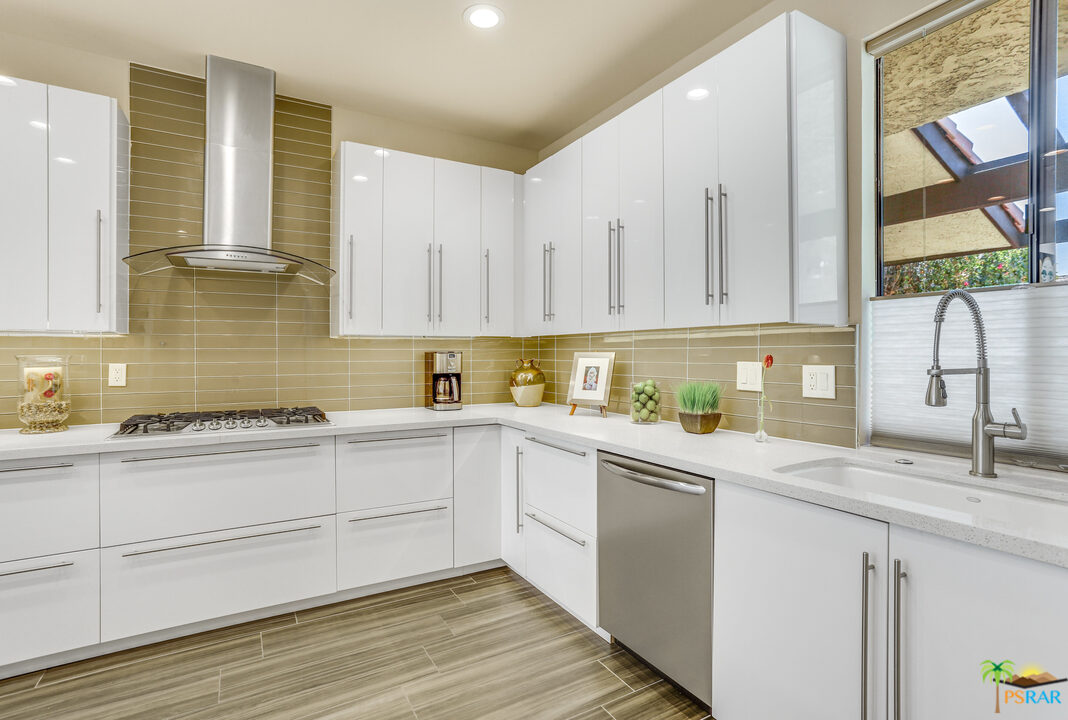 1314 East Andreas Road Palm Springs, CA 92262 - Photo 13 of 34 a kitchen with granite countertop white cabinets and white appliances