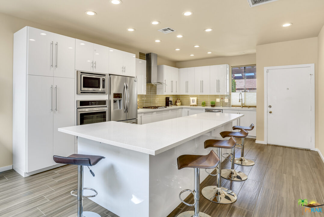 1314 East Andreas Road Palm Springs, CA 92262 - Photo 9 of 34 a kitchen with kitchen island wooden cabinets and refrigerator