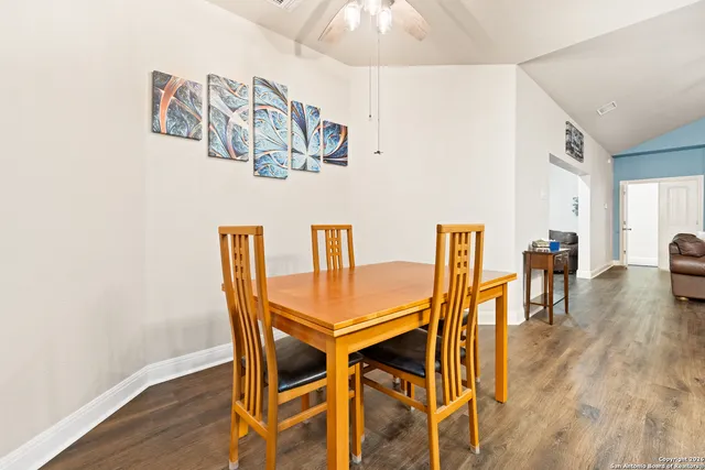 a kitchen with stainless steel appliances a white table chairs and a refrigerator