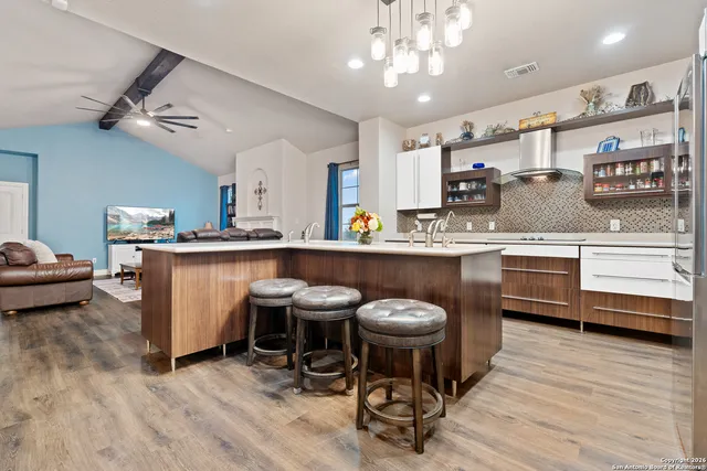 a kitchen with stainless steel appliances granite countertop a sink and white cabinets