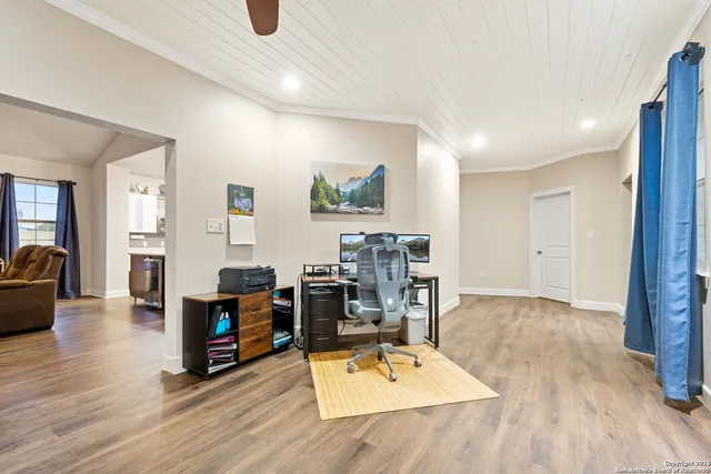 a bedroom with a large bed and a chandelier fan