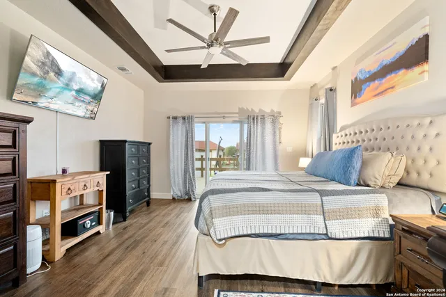 a bedroom with a bed a dresser and a flat screen tv