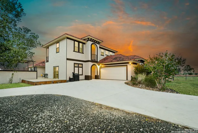 a view of a house with a yard and large trees