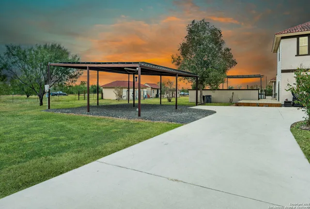 a view of a house with a big yard and large trees