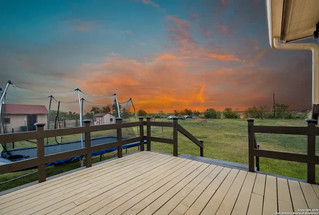 an aerial view of a house with a yard large trees and sitting area