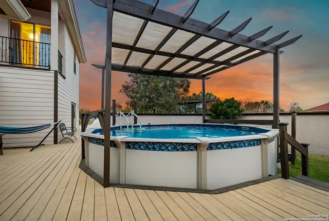 an aerial view of a house with swimming pool and a yard
