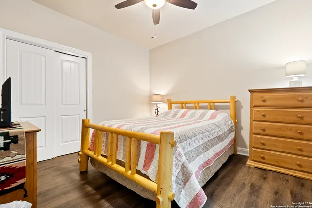 a bedroom with a bed and a flat tv screen on a dresser