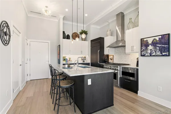 a kitchen with stainless steel appliances kitchen island a table chairs in it and wooden floors