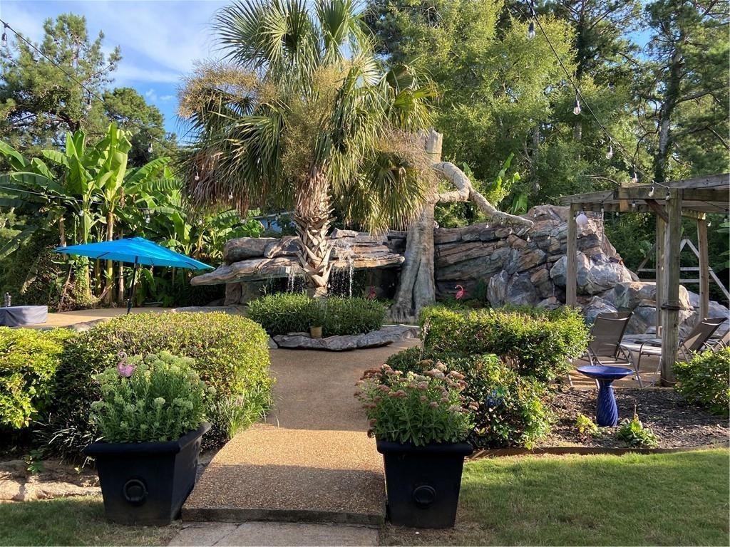 1679 Rangewood Drive Southwest Lilburn, GA 30047 - Photo 8 of 22 a view of a garden with plants and large trees