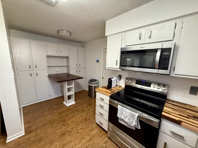 a kitchen with stainless steel appliances a stove a microwave and cabinets