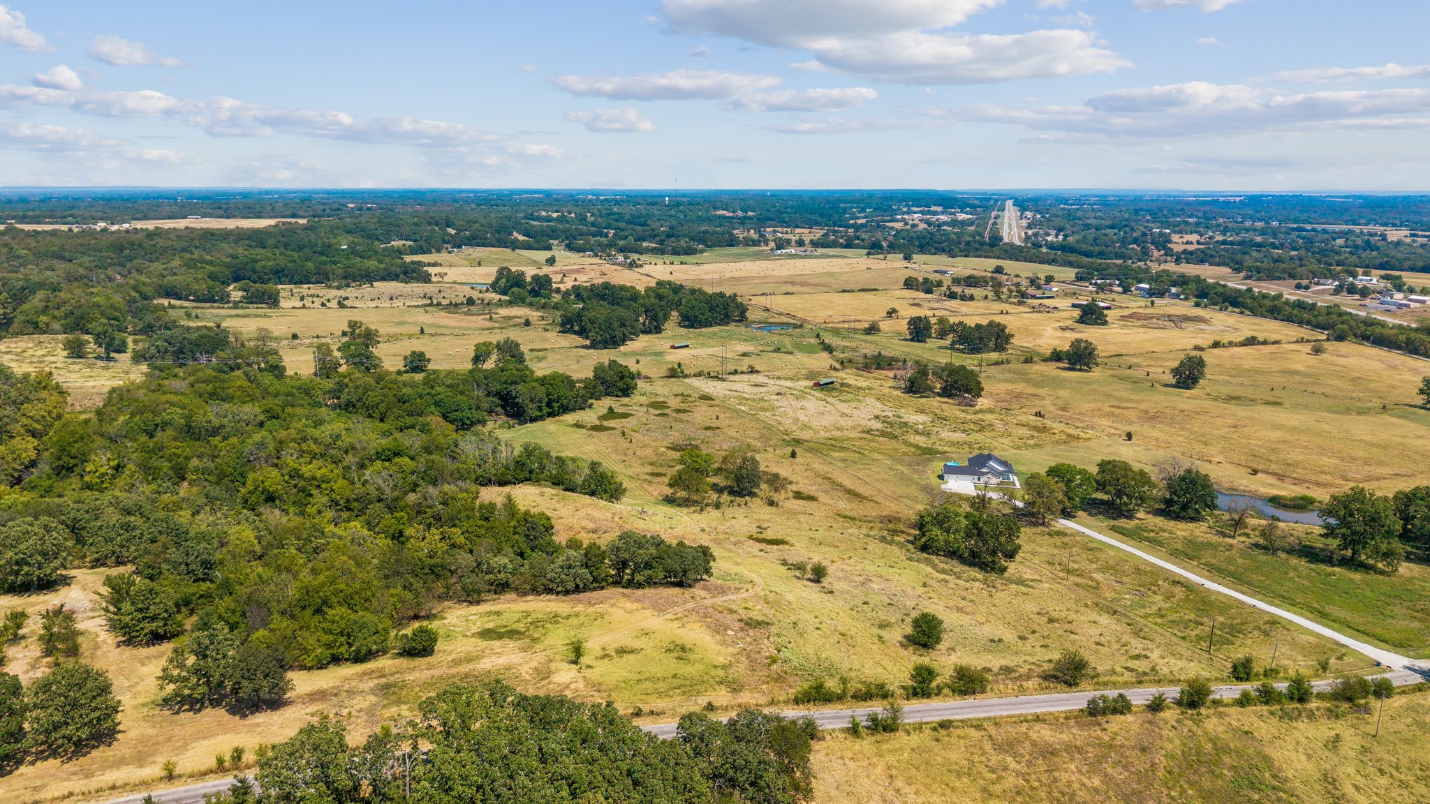 0 East 420 Road Claremore, OK 74017 - Photo 4 of 9 Expansive rural landscape with a single-story residence, a paved driveway, and mature trees