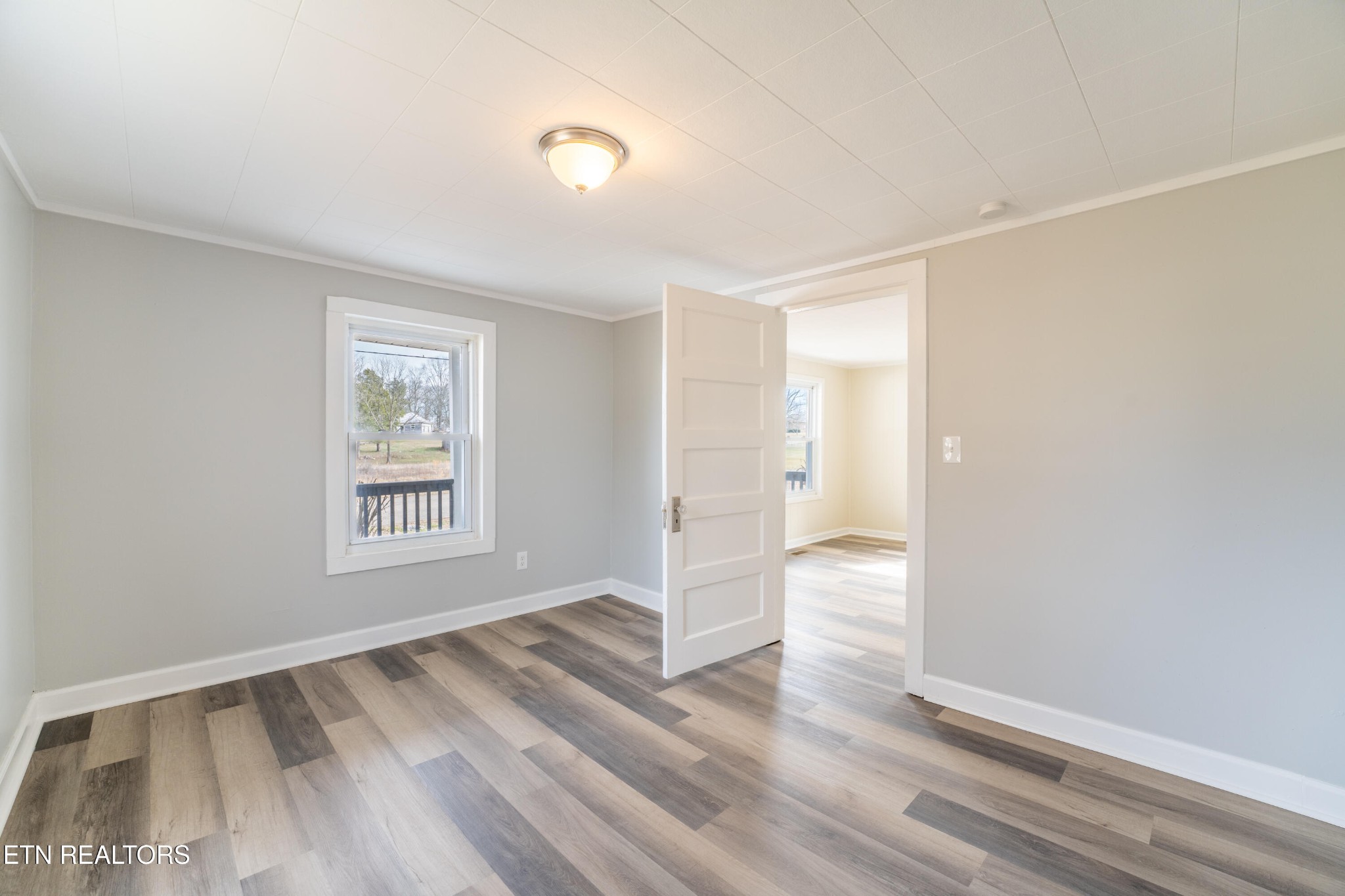 7909 Warwick Lane Corryton, TN 37721 - Photo 7 of 33 a view of an empty room with wooden floor and a window