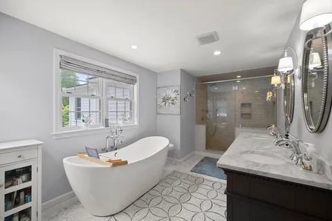 a bath room with a mirror and a bath tub