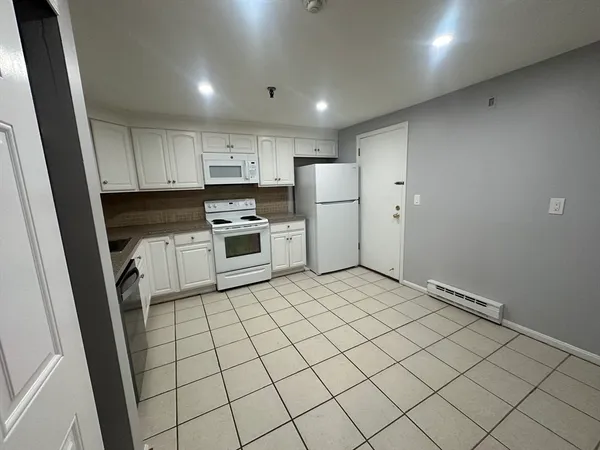 a kitchen with white cabinets and white appliances