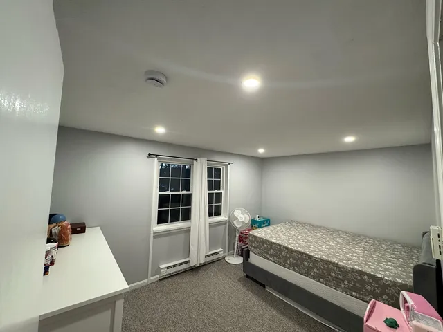 a spacious bedroom with a bed and a window