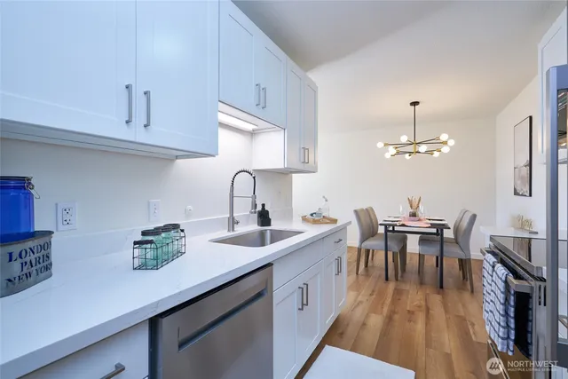 a kitchen with stainless steel appliances a sink a stove and cabinets